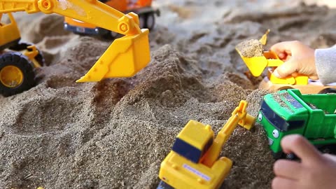 a child's hand playing sand with a toy