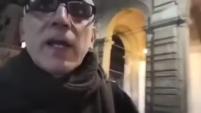 A PRIEST LAYS OUT WHOSE IN THE BACKGROUND PULLING THE STRINGS