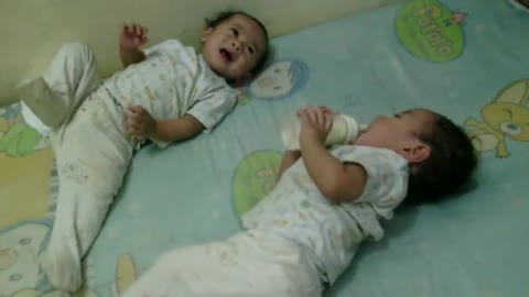 Funny Cute Twin Babies fighting for milk bottle