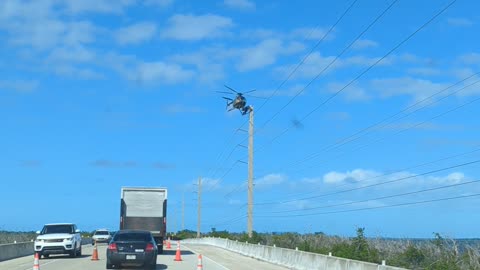 Linesman Balancing on Helicopter for Work