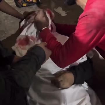 A man weeping over his brother’s body who was killed by an Israeli strike
