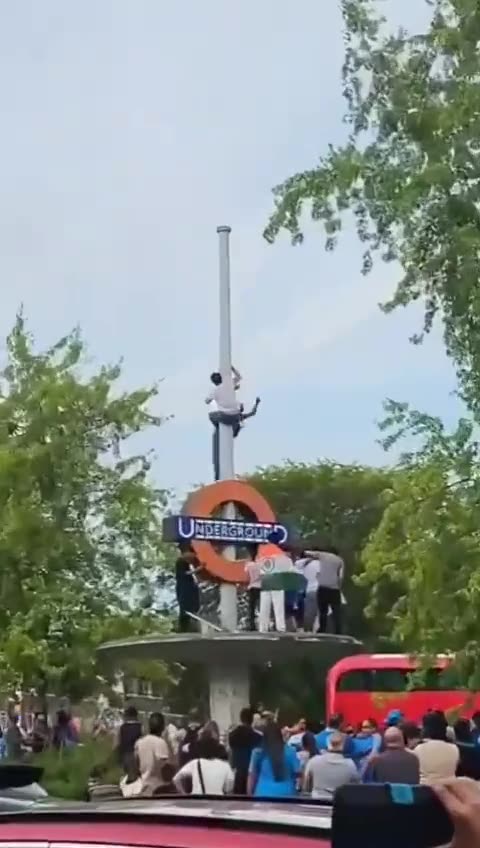 UK - Pajeet trying to tie an Indian flag to the underground sign falls down like a sack of shit