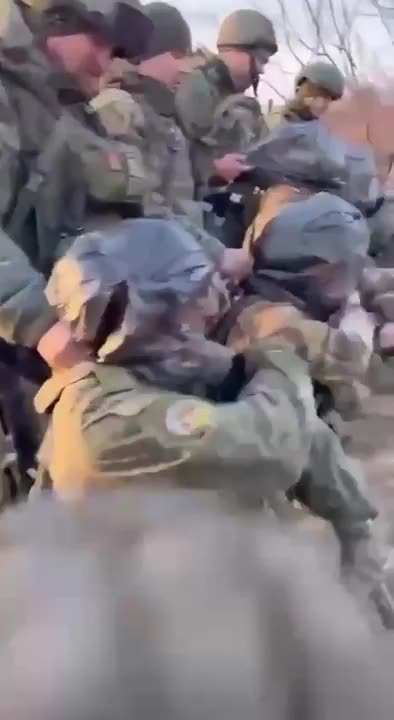 Russian soldiers training to apply a tourniquet with plastic bags on their heads