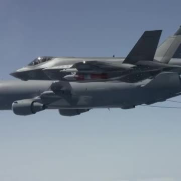In the air, an F-15C flies near a second plane.