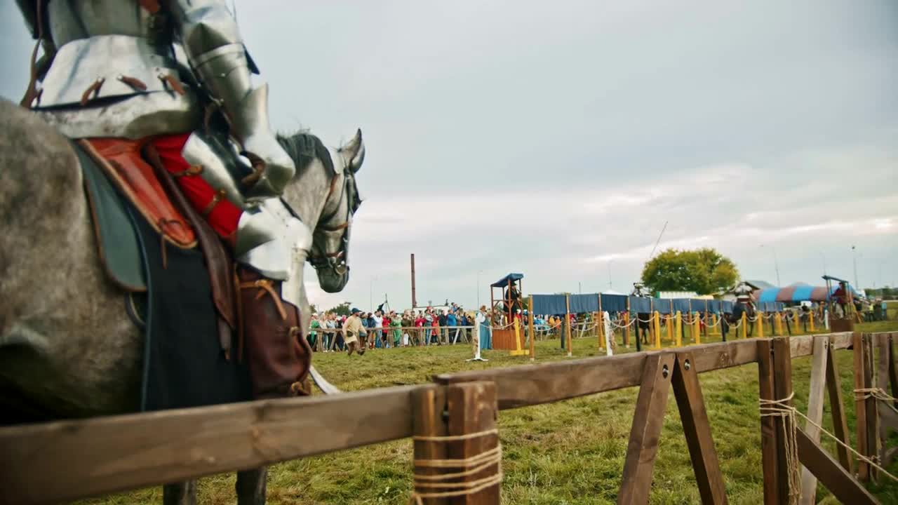 Knights battle on the green field - a man waiting for his turn astride a horse