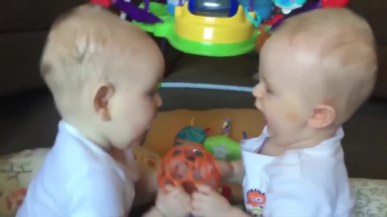 Twin babies act cute in front of their mother