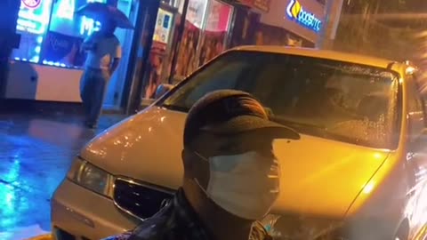 Woman Gives Umbrella to Man Waiting for Bus During Hurricane