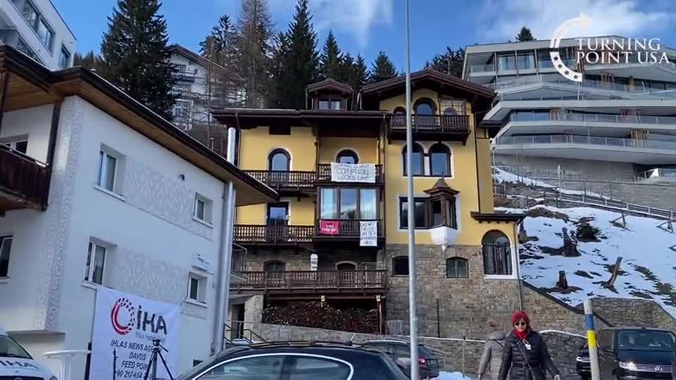 Davos resident with a welcome banner for the WEF: ...this is what corruption looks like!