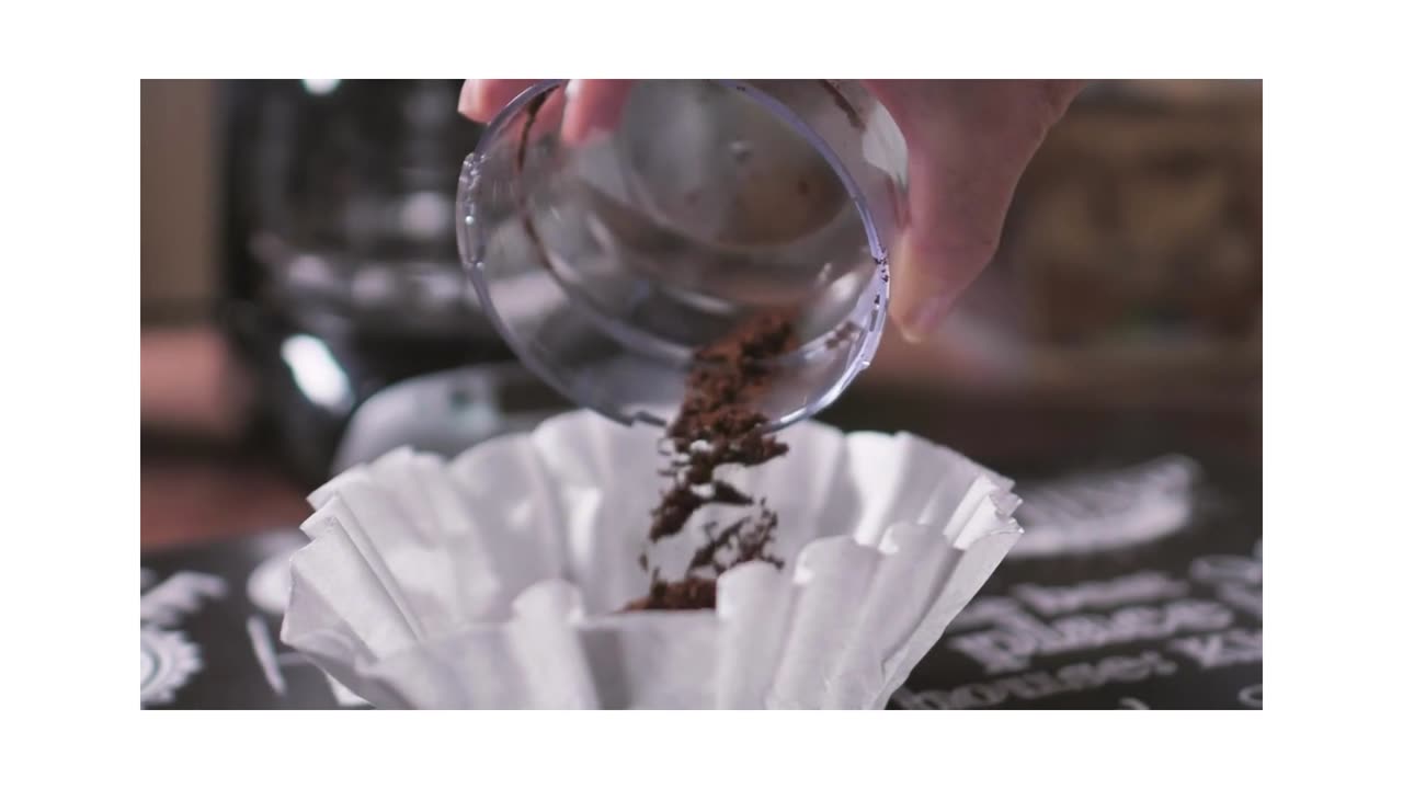 Coffee powder being poured on the coffee maker filter