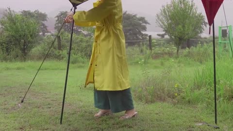 A man cooks outdoors in the rain