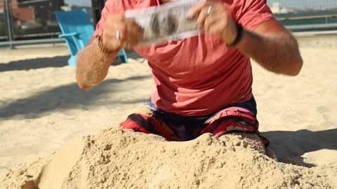 A Man Digging Money From The Sand