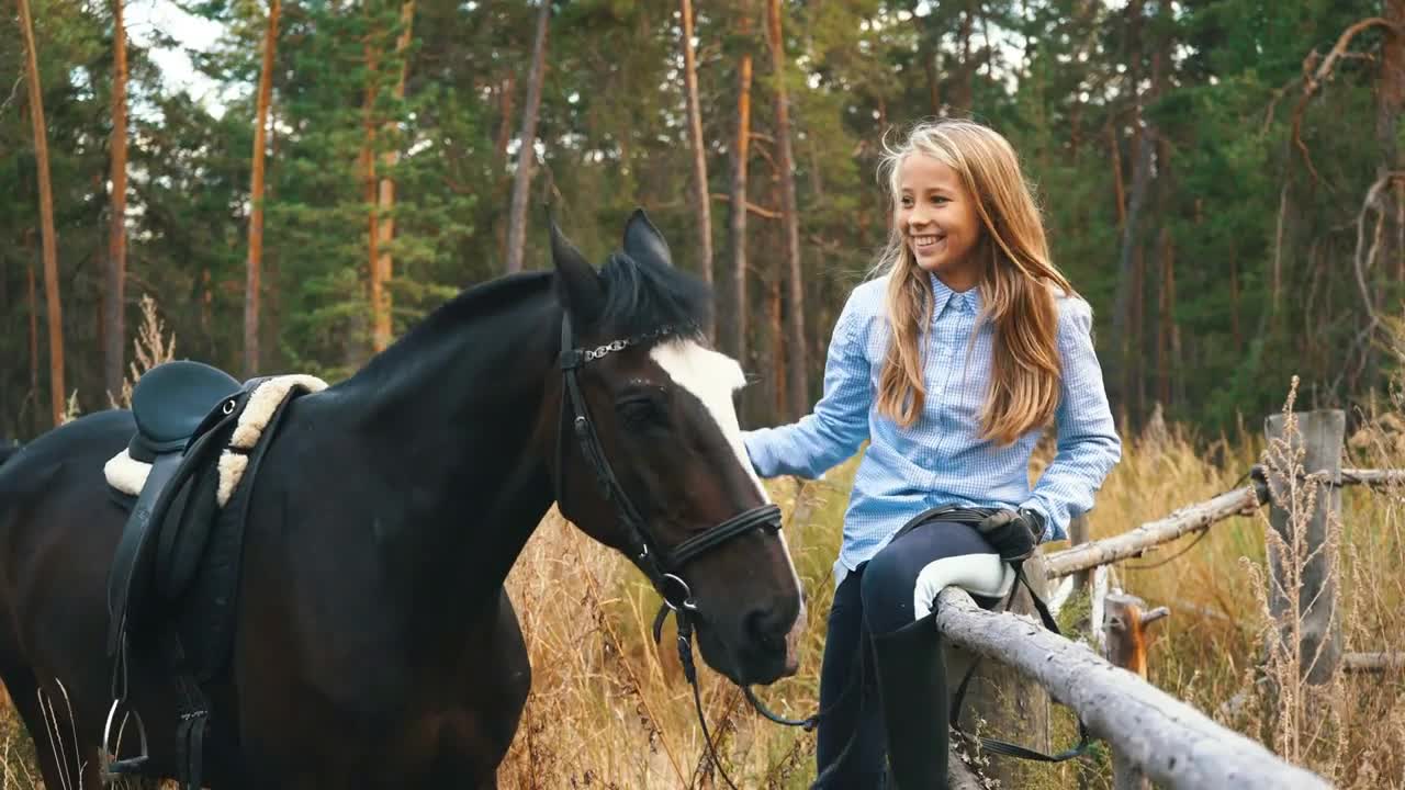 Beautiful girl cares for her horses. Focus on the girl