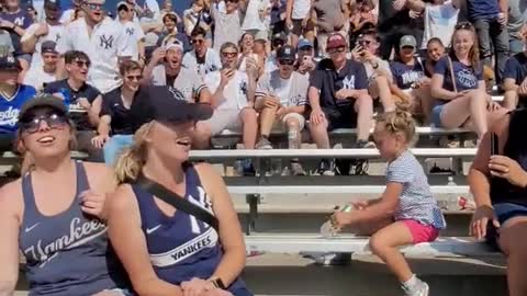 Yankees fans cheer a little girl landing a bottle flip