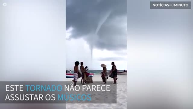 Músicos tocam durante tornado em praia