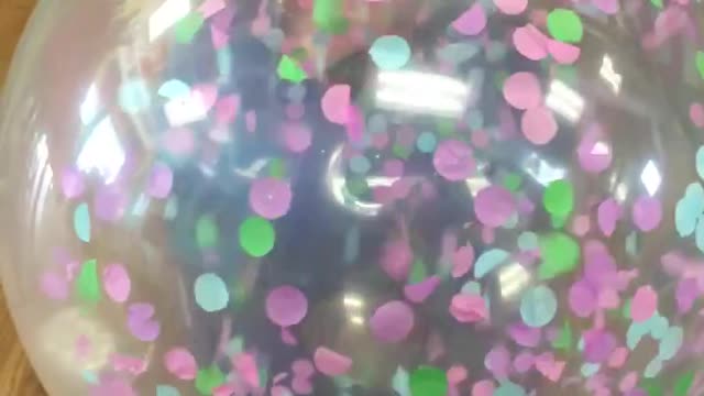 Slow motion balloon being filled with confetti