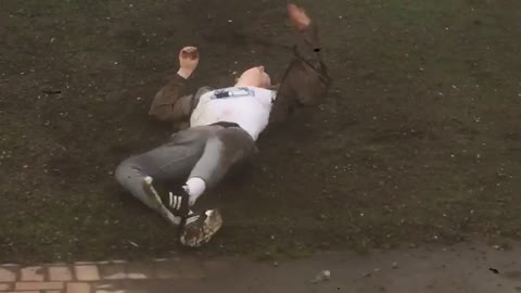 Guy in brown jacket rolling down hill