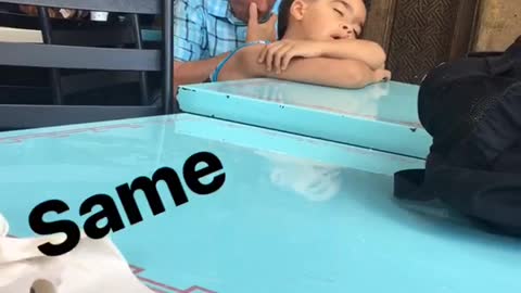 Same kid sleeping on blue table