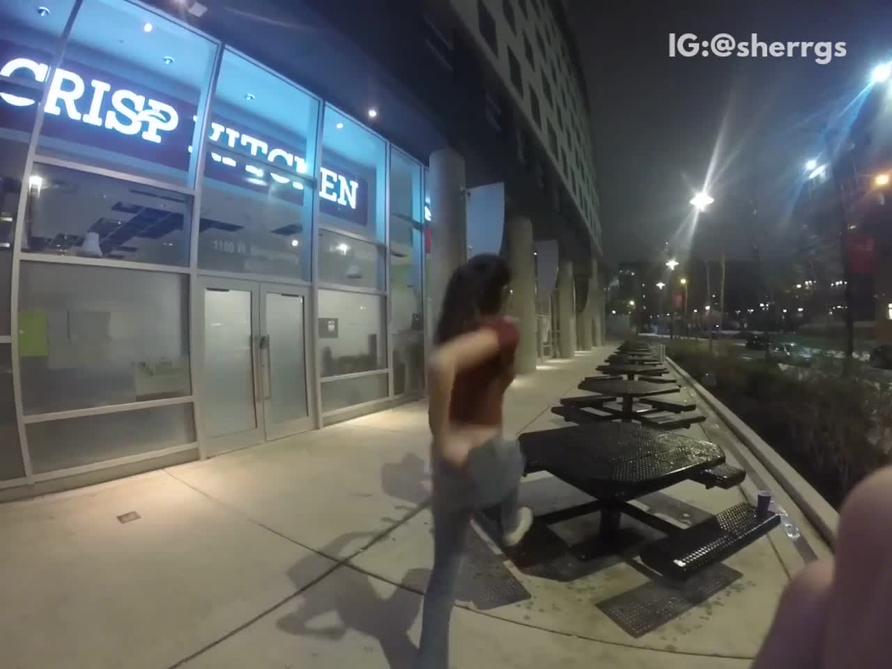 Girl dances with friends, climbs up on outside table, slips, and falls off