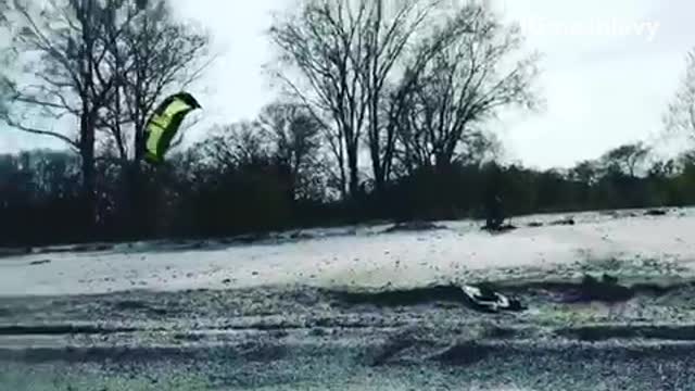 Kite surfing guy lands flip but ends up getting dragged onto sand shore