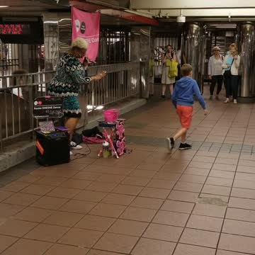 Big crowd around lady singing in subway blue dress