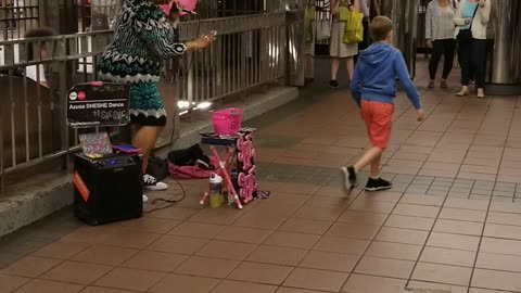 Big crowd around lady singing in subway blue dress