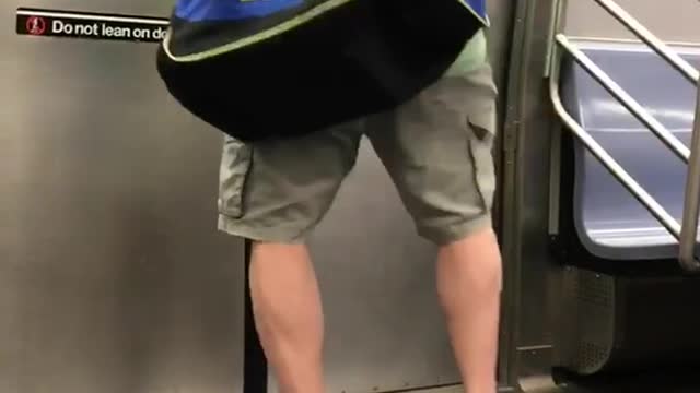 Bald guy green shirt dancing in front of subway door exit