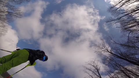 Guy skiing hits other guy and falls down in snow