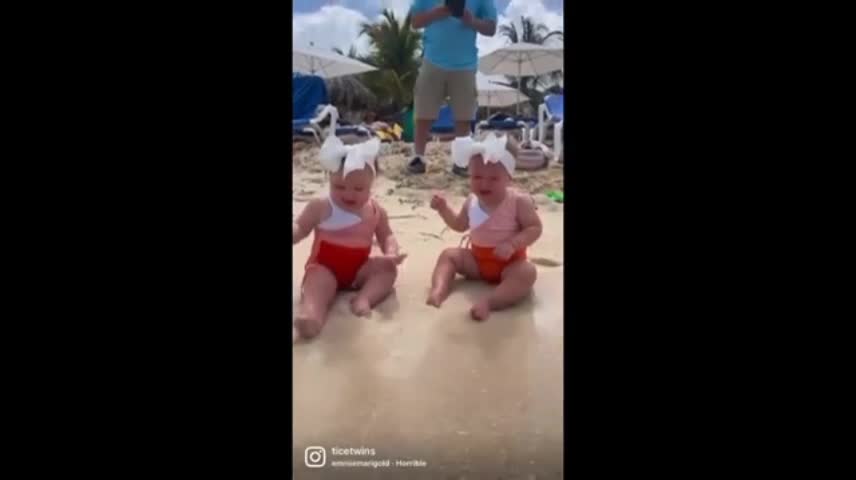 Twin babies adorably confused by ocean waves