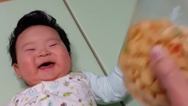 This is a video of a baby laughing so much at the sound of shaking cookies.