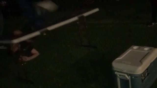 Music guy jumps from blue cooler to table outside at party