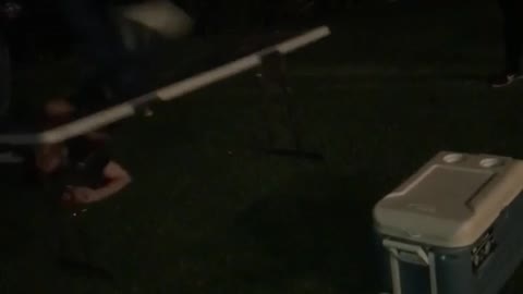 Music guy jumps from blue cooler to table outside at party