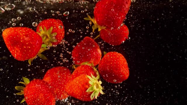 Astonishing slow motion view of strawberry deeps into water