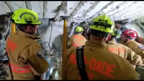 Firefighters working dangerous search-and-rescue effort in basement parking garage at the Surfside