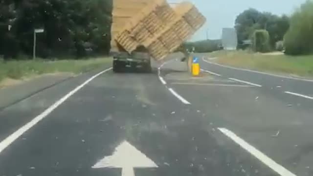 Truck Carrying Bales Of Hay Overturns After Losing Balance