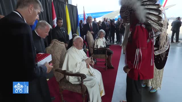 LA CERIMONIA DI BENVENUTO PER PAPA FRANCESCO IL CAPOMASTRO DELLA CUPOLA MASSONICO PAGANA SATANICA IN CANADA ACCOLTO DAGLI STREGONI INDIGENI E BACIA LA MANO AD UNA STREGONA INDIGENA GLI MANCA SOLO IL COPRICAPO DA STREGONE ORMAI