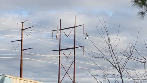 Men working on high voltage power lines