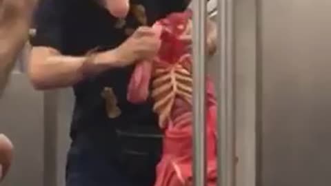 Man in blond wig playing with puppet on train