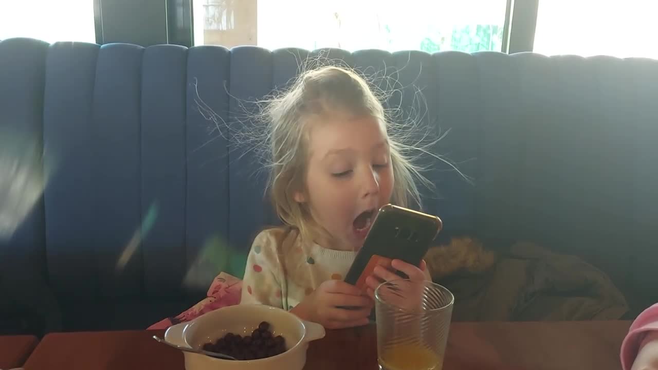 Cute toddler girl making selfies in a funny way