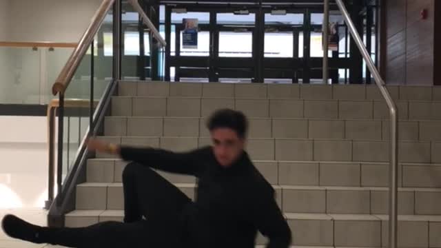 Guy in black sweater slides down stairs