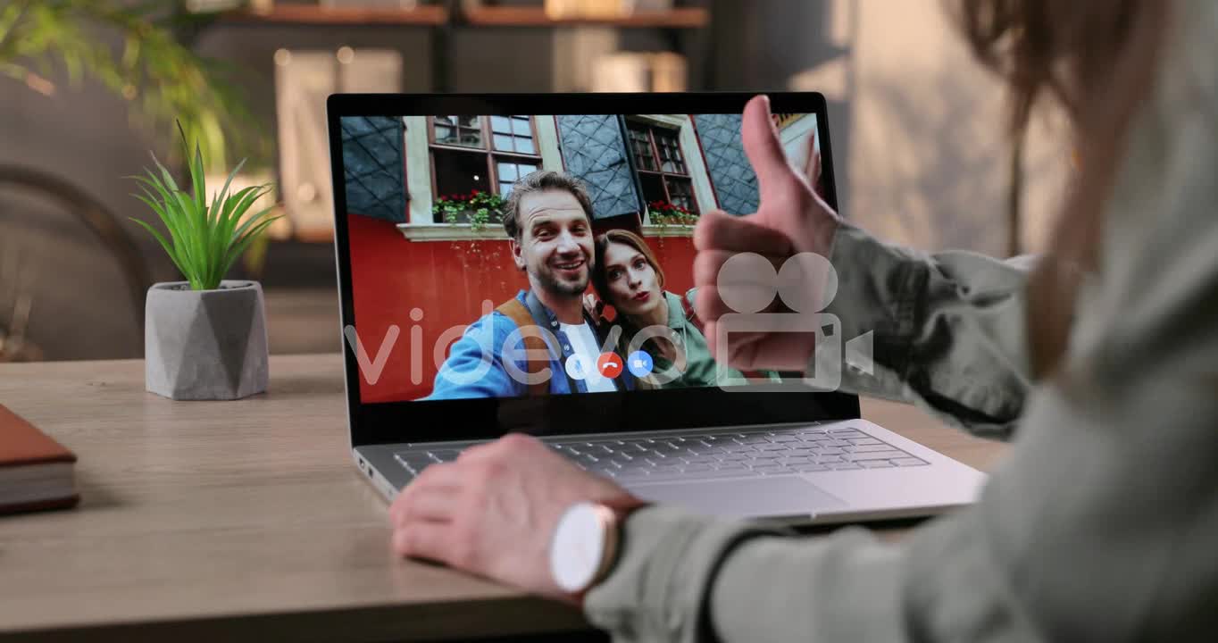 Woman Sitting At Table In Room And Video Chatting With Couple Of Happy Friends On Laptop