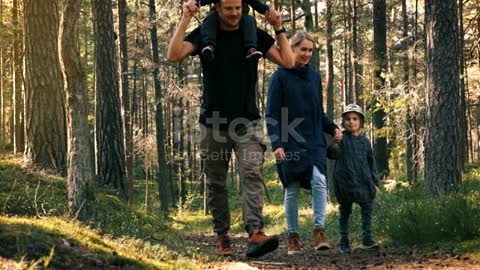 Active young family walks on the forest trail with children