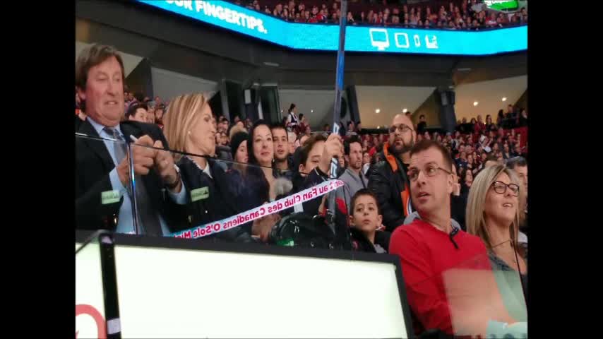 Wayne Gretzky gives a kid a stick.