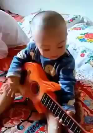 the child is playing the guitar and singing