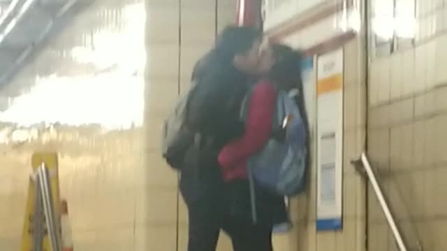 Couple making out at subway station
