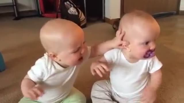 Twin cute baby girls fighting over pacifier