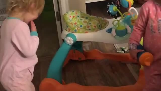Two blonde babies high five pacifier slap