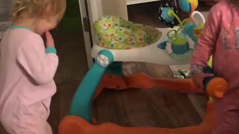 Two blonde babies high five pacifier slap