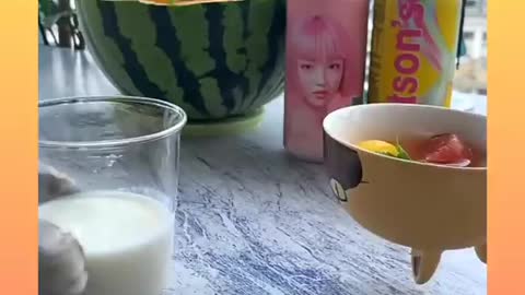 A cat surve a watermelon in a fantastic way