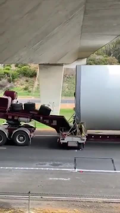 A car with goods at the limit of the height of the bridge
