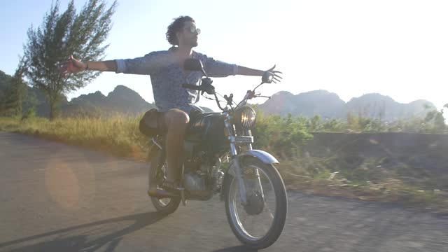 Man riding a motorbike with no hands